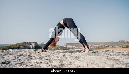 Frau, die Yoga auf dem Berggipfel praktiziert Stockfoto