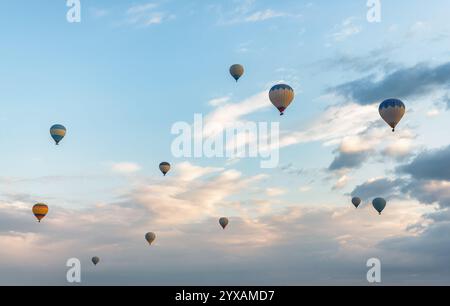 Fantastischer Blick auf die fliegenden bunten Heißluftballons bei Sonnenaufgang Stockfoto