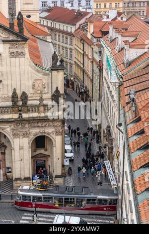 Prag, Tschechische Republik, 12. November 2024: Enge Straßen von Prag, in denen Straßenbahnen und Touristen zu Fuß verkehren. Stockfoto