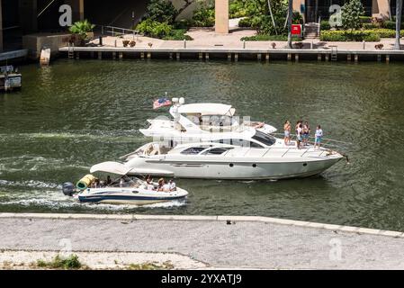 Miami, FL, USA - 30. März 2024: Motorboote und Yachten mit Urlaubern segeln auf dem Miami River in Miami, Florida, USA. Stockfoto