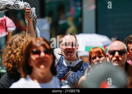 Melbourne, Australien. Dezember 2024. Ein Demonstrant winkt eine Hand, während er während der Kundgebung ein Plakat hält. Die Demonstranten schwenken palästinensische Flaggen und halten Banner, die ein Ende des Völkermords und der zionistischen Aggression fordern, und rufen in Solidarität für die palästinensische Befreiung und Gerechtigkeit. (Foto: YE Myo Khant/SOPA Images/SIPA USA) Credit: SIPA USA/Alamy Live News Stockfoto