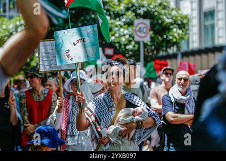 Melbourne, Australien. Dezember 2024. Ein Demonstrant trägt ein Baby, während er an der Demonstration teilnimmt. Die Demonstranten schwenken palästinensische Flaggen und halten Banner, die ein Ende des Völkermords und der zionistischen Aggression fordern, und rufen in Solidarität für die palästinensische Befreiung und Gerechtigkeit. (Foto: YE Myo Khant/SOPA Images/SIPA USA) Credit: SIPA USA/Alamy Live News Stockfoto