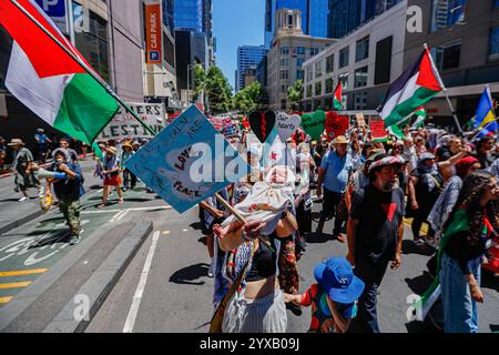 Melbourne, Australien. Dezember 2024. Ein Demonstrant trägt ein Baby, während er an der Demonstration teilnimmt. Die Demonstranten schwenken palästinensische Flaggen und halten Banner, die ein Ende des Völkermords und der zionistischen Aggression fordern, und rufen in Solidarität für die palästinensische Befreiung und Gerechtigkeit. (Foto: YE Myo Khant/SOPA Images/SIPA USA) Credit: SIPA USA/Alamy Live News Stockfoto