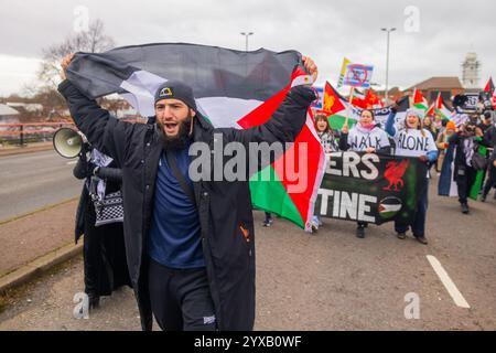 Birmingham, Großbritannien. DEZEMBER 2024. Der Mann hält die palästinensische Flagge, während eine pro-palästinensische Menschenmenge vom Handsworth Park ins Zentrum von Birmingham marschierte, sang die Gruppe, einschließlich derer, die als Teil von Healthworkers 4 Palestine Peelings trugen, und zündete Fackeln an. Gruppen aus Liverpool und London schlossen sich an. Credit Milo Chandler/Alamy Live News Stockfoto