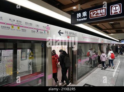 Peking, China. Dezember 2024. Passagiere steigen am Bahnhof Jimen Qiao in Peking, Hauptstadt von China, am 15. Dezember 2024 in einen Zug der Pekinger U-Bahn Changping Line ein. Drei neue U-Bahn-Linien wurden am Sonntag in Peking eröffnet, wodurch die Gesamtlänge der Stadt auf 879 Kilometer erhöht wurde, was den ersten Platz unter den chinesischen Metropolen belegt. Quelle: Zhang Chenlin/Xinhua/Alamy Live News Stockfoto