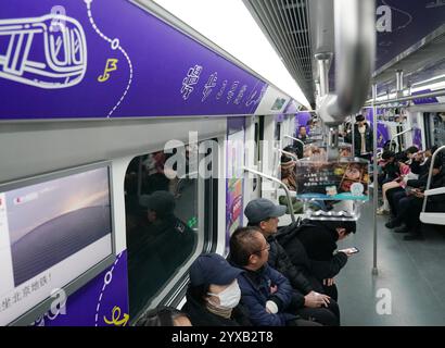 Peking, China. Dezember 2024. Passagiere nehmen am 15. Dezember 2024 einen Zug der Pekinger U-Bahn-Linie 3 in Peking, Hauptstadt Chinas. Drei neue U-Bahn-Linien wurden am Sonntag in Peking eröffnet, wodurch die Gesamtlänge der Stadt auf 879 Kilometer erhöht wurde, was den ersten Platz unter den chinesischen Metropolen belegt. Quelle: Zhang Chenlin/Xinhua/Alamy Live News Stockfoto