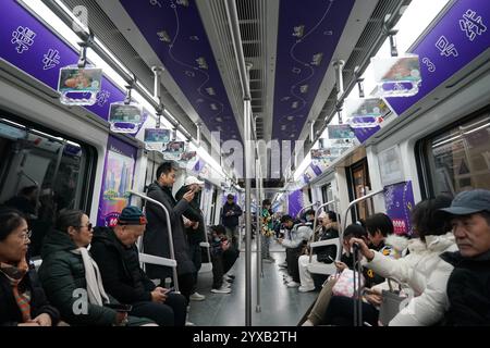 Peking, China. Dezember 2024. Passagiere nehmen am 15. Dezember 2024 einen Zug der Pekinger U-Bahn-Linie 3 in Peking, Hauptstadt Chinas. Drei neue U-Bahn-Linien wurden am Sonntag in Peking eröffnet, wodurch die Gesamtlänge der Stadt auf 879 Kilometer erhöht wurde, was den ersten Platz unter den chinesischen Metropolen belegt. Quelle: Zhang Chenlin/Xinhua/Alamy Live News Stockfoto