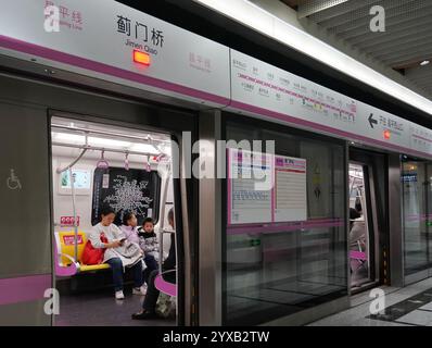 Peking, China. Dezember 2024. Passagiere nehmen am 15. Dezember 2024 am Bahnhof Jimen Qiao in Peking, Hauptstadt Chinas, einen Zug der Pekinger U-Bahn Changping Line. Drei neue U-Bahn-Linien wurden am Sonntag in Peking eröffnet, wodurch die Gesamtlänge der Stadt auf 879 Kilometer erhöht wurde, was den ersten Platz unter den chinesischen Metropolen belegt. Quelle: Zhang Chenlin/Xinhua/Alamy Live News Stockfoto