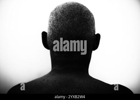 Nahaufnahme des Hinterteils eines rasierten Mannes im dunklen Licht Stockfoto