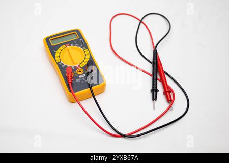 Gelbes und graues Multimeter mit roten und schwarzen Fühlern zur Messung von Spannung, Widerstand und Strom auf weißem Hintergrund Stockfoto