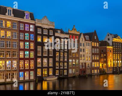 Typisch holländische Architektur, malerische Kanalhäuser in Amsterdam Damrak am Abend Stockfoto