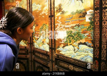 (241215) -- PEKING, 15. Dezember 2024 (Xinhua) -- ein Lehrling von Hu Xin sieht sich ein Meisterwerk der Gold Lack Inlay Art im Pekinger Gold Lack Inlay Art Museum in Peking, Hauptstadt von China, 10. Dezember 2024 an. Gold Lack Inlay Art, eine Hauptkategorie traditioneller chinesischer Lackkunst, hat eine mehr als 7.000-jährige Geschichte. Die Pekinger Goldlackintarsien, die sich auf der Grundlage der kaiserlichen Kunst der Ming- (1368-1644) und Qing-Dynastien (1644-1911) entwickeln, bilden einen klassisch eleganten und prächtigen Pekinger Stil. Die Kunst wurde auf eine breite Palette von Aspekten des Lebens angewendet, von Stockfoto