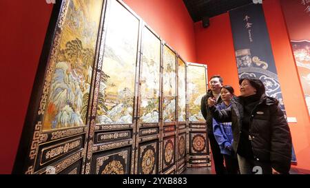 (241215) -- PEKING, 15. Dezember 2024 (Xinhua) -- Hu Xin (R) stellt ihren Auszubildenden ein Meisterwerk der Gold Lack Inlay Art Art Museum in Peking, Hauptstadt Chinas, am 10. Dezember 2024 vor. Gold Lack Inlay Art, eine Hauptkategorie traditioneller chinesischer Lackkunst, hat eine mehr als 7.000-jährige Geschichte. Die Pekinger Goldlackintarsien, die sich auf der Grundlage der kaiserlichen Kunst der Ming- (1368-1644) und Qing-Dynastien (1644-1911) entwickeln, bilden einen klassisch eleganten und prächtigen Pekinger Stil. Die Kunst wurde auf eine breite Palette von Aspekten in li angewendet Stockfoto