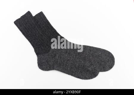 Ein Paar dunkelgraue Wollsocken, handgestrickt mit einem einfachen und soliden Design. Die Socken wirken warm, weich und strapazierfähig, ideal für Winterkleidung und Showcasi Stockfoto