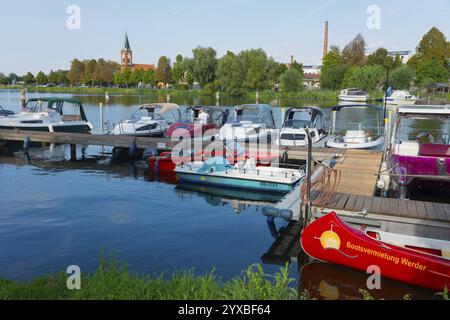 Ein Hafen mit mehreren Booten und einer Kirche im Hintergrund, Maria Meeresstern Kirche, Altstadtinsel Werder in der Havel, Potsdam-Mittelmark, Bra Stockfoto