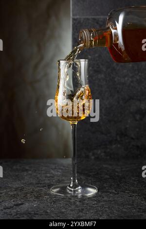 Starkes alkoholisches Getränk aus einer Flasche in ein Glas gießen. Kopierbereich. Stockfoto