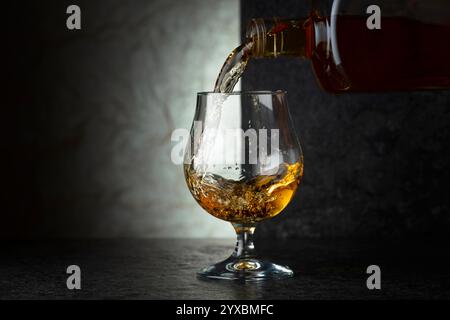 Schnaps aus einer Flasche in ein Glas gießen. Speicherplatz kopieren. Stockfoto