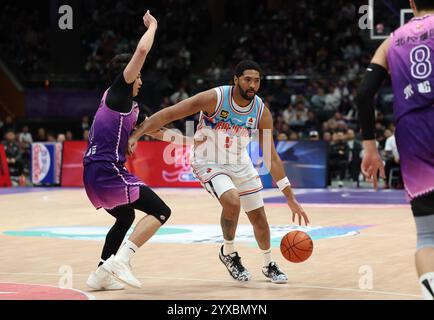 Peking, China. Dezember 2024. Dedric Lawson (R) von Xinjiang Flying Tigers durchbricht während eines Spiels zwischen Beijing Royal Fighters und Xinjiang Flying Tigers in der Saison 2024-2025 der chinesischen Basketball Association (CBA) Liga in Peking, China, 15. Dezember 2024. Quelle: Wang Kaiyan/Xinhua/Alamy Live News Stockfoto