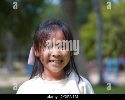 Porträt eines lächelnden kleinen Mädchens in einem Park an einem sonnigen Tag. Stockfoto