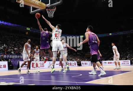 Peking, China. Dezember 2024. Grant Riller (Top L) von Beijing Royal Fighters macht einen Layup während eines Spiels zwischen Beijing Royal Fighters und Xinjiang Flying Tigers in der Saison 2024-2025 der chinesischen Basketball Association (CBA) Liga in Peking, China, 15. Dezember 2024. Quelle: Wang Kaiyan/Xinhua/Alamy Live News Stockfoto
