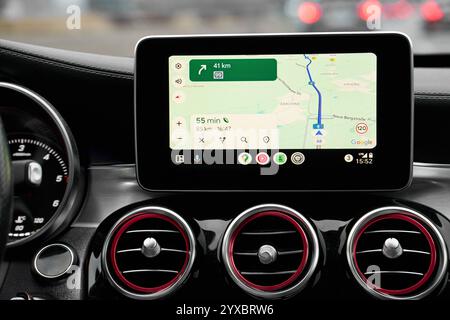 Bayern, Deutschland - 14. Dezember 2024: Google Maps Navigation auf einem Infotainmentsystem im Auto, Show Route und Ankunftszeit, umgeben von stilvollen Lüftungsschlitzen mit roten Akzenten auf einer Fahrt auf der Autobahn *** Google Maps Navigation auf einem Infotainmentsystem im Auto, Show Route und Ankunftszeit, umgeben von stilvollen Lüftungsschlitzen mit roten Akzenten auf einer Fahrt auf der Autobahn Stockfoto