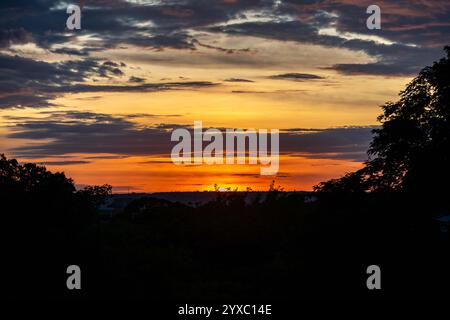 Dramatischer Sonnenaufgang mit intensiven natürlichen orangen Lichtern und idyllischer dramatischer Landschaft Stockfoto