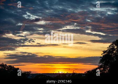 Dramatischer Sonnenaufgang mit intensiven natürlichen orangen Lichtern und idyllischer dramatischer Landschaft Stockfoto