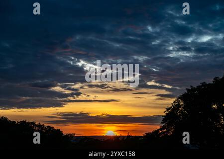 Dramatischer Sonnenaufgang mit intensiven natürlichen orangen Lichtern und idyllischer dramatischer Landschaft Stockfoto