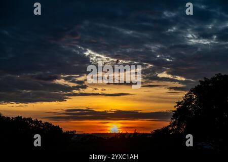 Dramatischer Sonnenaufgang mit intensiven natürlichen orangen Lichtern und idyllischer dramatischer Landschaft Stockfoto