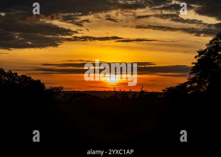 Dramatischer Sonnenaufgang mit intensiven natürlichen orangen Lichtern und idyllischer dramatischer Landschaft Stockfoto