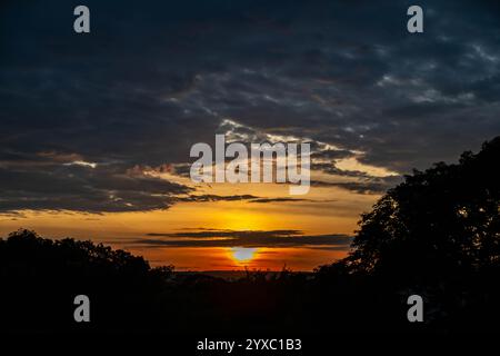 Dramatischer Sonnenaufgang mit intensiven natürlichen orangen Lichtern und idyllischer dramatischer Landschaft Stockfoto