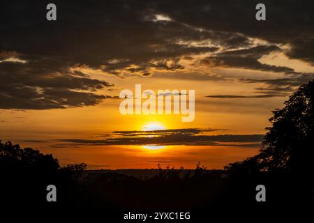 Dramatischer Sonnenaufgang mit intensiven natürlichen orangen Lichtern und idyllischer dramatischer Landschaft Stockfoto