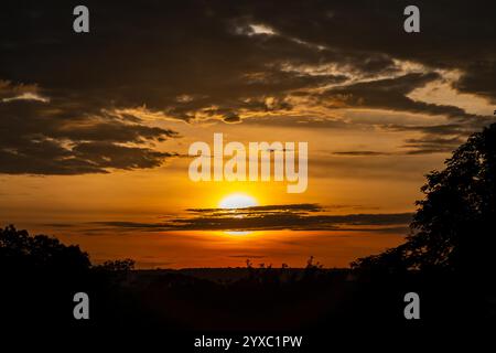 Dramatischer Sonnenaufgang mit intensiven natürlichen orangen Lichtern und idyllischer dramatischer Landschaft Stockfoto