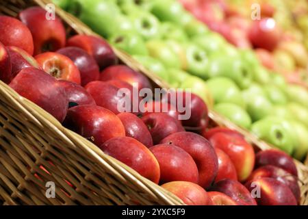Rote und grüne Äpfel in Korbkörben. Frische Ernte, reife Früchte im Supermarkt Stockfoto