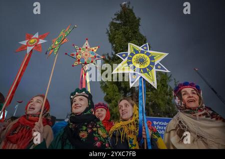 London, Großbritannien. Dezember 2024. Ukrainische Weihnachtslieder auf dem Trafalgar-Platz. Briten-Ukrainer in traditioneller festlicher Kleidung in der Nähe der kürzlich installierten norwegischen Weihnachtsfichte, um Lieder zu singen. Derzeit im neunten Jahr wird die ukrainische carol-Veranstaltung von britisch-ukrainischer Hilfe organisiert, um weitere Spenden für den Kauf von Generatoren und medizinische Hilfe für ukrainische Krankenhäuser und Unterkünfte zu sammeln. Guy Corbishley/Alamy Live News Stockfoto