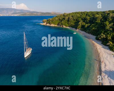 Segelboot vor Anker an einem malerischen Strand mit türkisfarbenem Wasser. Stockfoto