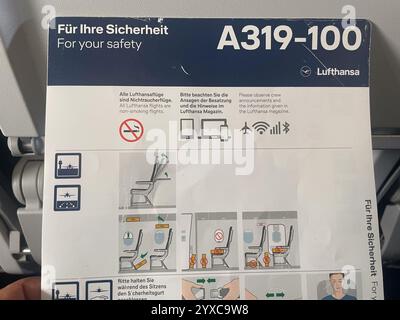 Eine Lufthansa A319-100 Sicherheitsanweisungskarte mit Rauchverboten, Abbildungen zur Sitzeinstellung und Notfallmaßnahmen, mit Diagrammen und m Stockfoto