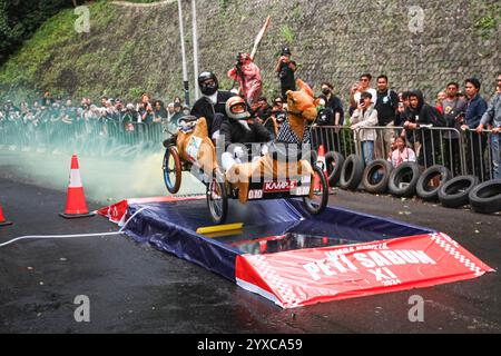 Bandung, Indonesien. Dezember 2024. Die Teilnehmer haben den letzten Sprung beim SOAP Box Derby in Bandung, West Java, Indonesien, am 15. Dezember 2024 geschafft. Mehr als 120 Teilnahmen sind eingegangen. Die Richter stimmen über die Beiträge hinsichtlich Leistung, Gesamtlook und Zeit ab. Die Fans stimmen für ihr Lieblingsteam aus der Seifenbox. (Foto: Algi Febri Sugita/NurPhoto) Credit: NurPhoto SRL/Alamy Live News Stockfoto