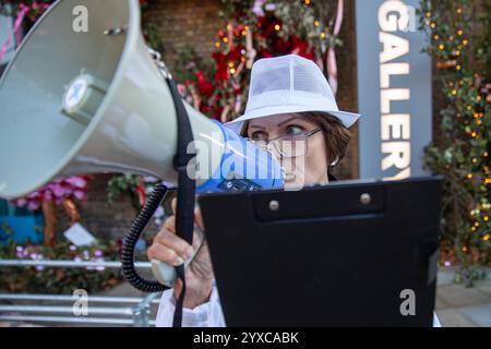 London, Chelsea, Großbritannien. Dezember 2024. Ein Tierschützer hält ein Clipboard, das in ein Megaphon ruft. Mitglieder von Speciesism und Animal Justice halten eine Demonstration vor der Saatchi-Galerie in Chelsea ab. Die Aktivisten nehmen an einer Show Teil, die von der Künstlerin Stephanie Lane entworfen wurde, um auf die Behandlung von Schweinen in der Landwirtschaft und Lebensmittelindustrie aufmerksam zu machen. (Credit Image: © James Willoughby/SOPA Images via ZUMA Press Wire) NUR REDAKTIONELLE VERWENDUNG! Nicht für kommerzielle ZWECKE! Stockfoto