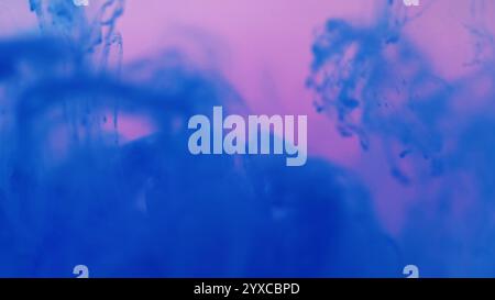 Heller Mix Tropfen. Spritzwasser. Defokussierte funkelnde flüssige blaue Farbe flüssige magische rauchige Wolken auf abstraktem rosa Kunsthintergrund. Stockfoto