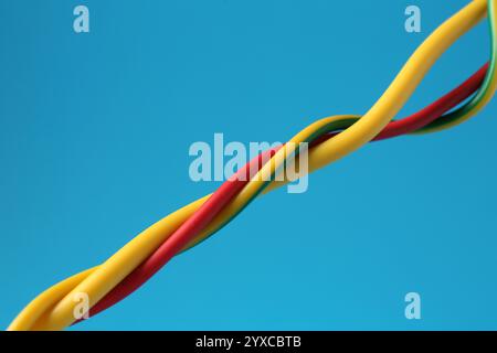 Viele farbige elektrische Drähte auf hellblauem Hintergrund, Nahaufnahme Stockfoto
