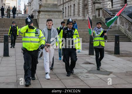 London, Großbritannien. Dezember 2024. Polizeibeamte verhaften während einer Demonstration für Palästina einen pro-palästinensischen Aktivisten. Auf die Kundgebung, die von der Palästinensischen Solidaritätskampagne (PSC), Stop the war Coalition, CND, der Muslimischen Vereinigung Großbritanniens und dem Palästinensischen Forum in Großbritannien organisiert wurde, folgte ein Protest bei Kerzenlicht vor der Downing Street zum Gedenken an die 44.500 Menschen, die in den letzten 14 Monaten in Gaza getötet wurden. Quelle: Mark Kerrison/Alamy Live News Stockfoto