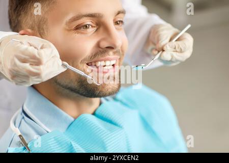 Junger Mann, der vom Zahnarzt mit zahnärztlichen Werkzeugen untersucht wird, um eine ordnungsgemäße Mundpflege und Behandlung sicherzustellen. Stockfoto