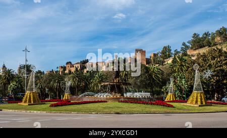 Brunnen der drei Gnaden mit der maurischen Zitadelle im Hintergrund in Malaga, Spanien. Stockfoto