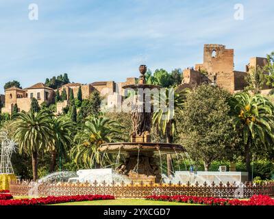 Brunnen der drei Gnaden mit der maurischen Zitadelle im Hintergrund in Malaga, Spanien. Stockfoto