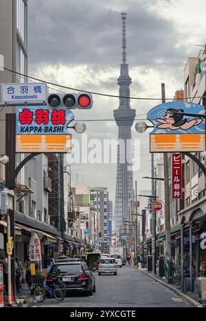 tokio, taitō - april 30 2024: Kappabashi-dori Straße bekannt für ihre Küchenartikel-Geschäfte und den hohen Tokyo Skytree Tower mit lebhaften Schildern, L Stockfoto