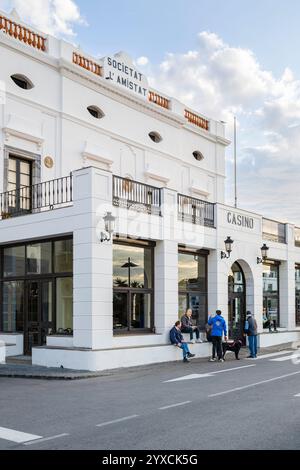 Männer warten auf die Eröffnung der Casino Bar an einem sonnigen Morgen an der Hafenpromenade von Cadaqués, Katalonien, Spanien Stockfoto