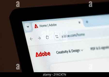 New York, USA – 15. Dezember 2024: Die Homepage der Adobe-Website wird auf dem Computerbildschirm mit sichtbarem Logo angezeigt. Online-Plattform für kreative Software Stockfoto