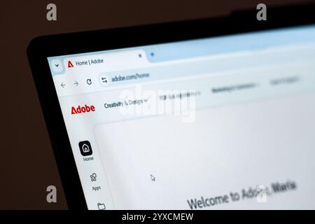 New York, USA – 15. Dezember 2024: Die Homepage der Adobe-Website wird auf dem Computerbildschirm mit sichtbarem Logo angezeigt. Online-Plattform für kreative Software Stockfoto