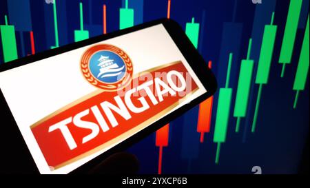 Konskie, Polen - 14. Dezember 2024: Das Firmenlogo von Tsingtao wird auf dem Mobiltelefon angezeigt Stockfoto